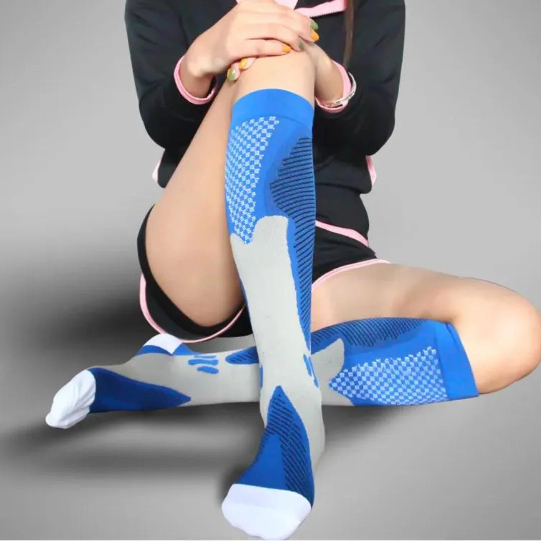 Eine Frau präsentiert im Sitzen die orthopädischen Kompressionsstrümpfe von RevitalCare in Blau, welche die Beine elegant stützen und für sportliche wie alltägliche Anlässe ideal sind.